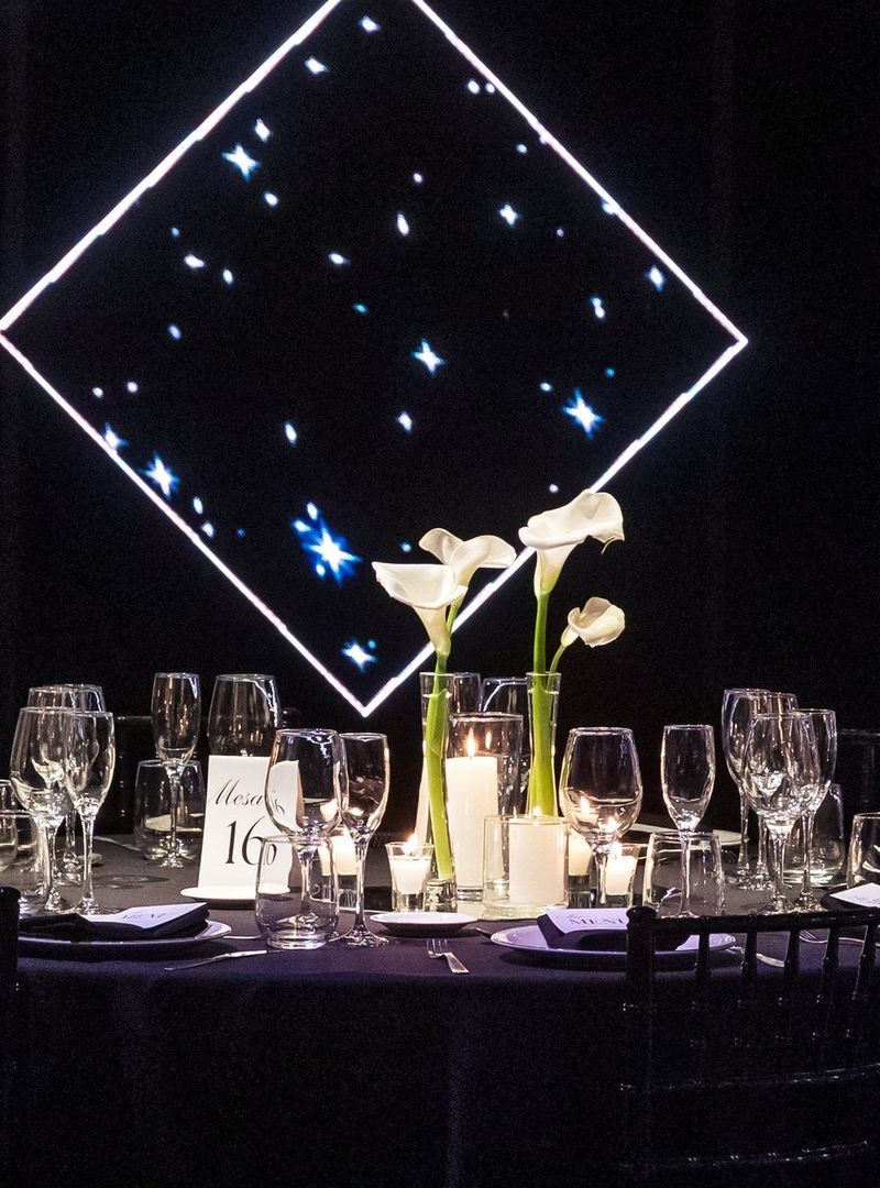 Mesa montada en el salón de Bayres Eventos con vajilla formal y velas